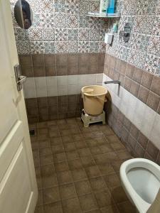 La salle de bains est pourvue de toilettes et d'un seau. dans l'établissement LBS Farmstay, à Alāndurai 9 autres photos