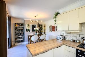Una cocina con gabinetes blancos y una mesa con sillas. en Warrington - Large Beautiful Home - Great Location In South West By StayStaycations, en Bristol