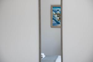 Un espejo en una habitación con un cuadro en la pared. en Pavilion Apt Cozy 2BR by Elysio, en Paralimni