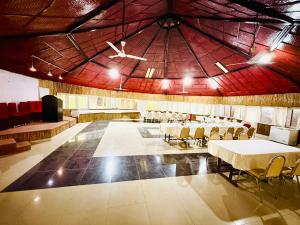 una grande stanza con tavoli e sedie di Hotel Mantra and Adventure a Sauraha