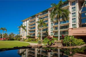 un grande condominio con uno stagno e delle palme di Honua Kai Hokulani 310 by Coldwell Banker Island Vacations a Kaanapali