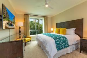 una camera da letto con un letto grande e una finestra di Honua Kai Konea 250 by Coldwell Banker Island Vacations a Kaanapali