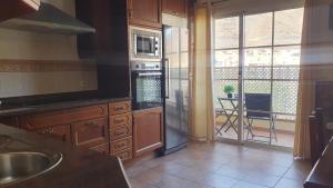 una cucina con lavello e fornello forno superiore di Apartamento Carmen a Morro del Jable Altre 10 foto