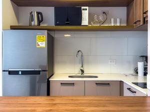 a kitchen with a sink and a microwave at The Hood 102, Modern and Luxury Apartments in Bogotá