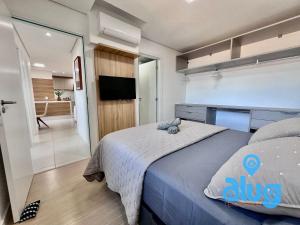 a bedroom with a bed and a tv and a bathroom at S806T1 Vista Incrível + Beto Carrero e Praia! in Penha +66 photos