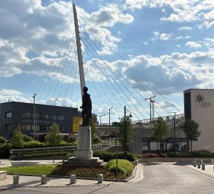 a statue of a man standing next to a pole at ÁTRIUM Apartman Kaposvár in Kaposvár