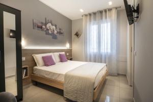 a bedroom with a large bed with purple pillows at Affittacamere Orchidea for Tourists Hesperia Hosp in Modena