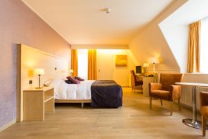 a hotel room with a bed and a desk at Brinkhotel in Zuidlaren