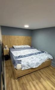 a bedroom with a bed with a blue wall at 777tsrj in Muruntau