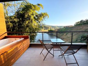 balcone con vasca, 2 sedie e tavolo di Rooca Habitat Guatape a Guatapé