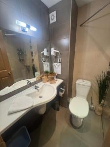 a bathroom with a white toilet and a sink at STUDIO 46 South Pearl Homes in Sozopol