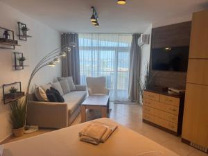 a living room with a couch and a tv at STUDIO 46 South Pearl Homes in Sozopol
