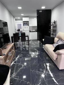 un soggiorno con pavimento in marmo e divano di IN LOVE a Mahora Altre 35 foto