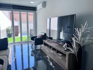 a living room with a flat screen tv and a couch at IN LOVE in Mahora