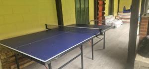 a ping pong table in a room with at Albergue Las Mimosas del Nalón in San Juan de la Arena