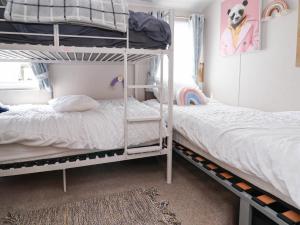 a bedroom with two bunk beds and a window at Lawi39 in Abergele