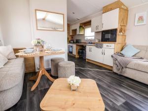 a living room with a table and a kitchen at Lawi39 in Abergele