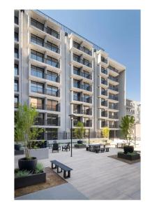 ein großes Apartmenthaus mit Bänken im Innenhof in der Unterkunft Centro Cívico - GYM - Piscina - WiFi - Terraza - Security 24-7 in Santiago