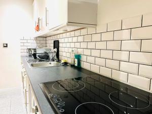 a kitchen with a stove top oven next to a sink at Flat on the High St in Beckenham
