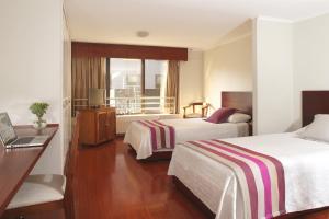 una camera d'albergo con due letti e una finestra di MR Apart Providencia (ex Apart Neruda) a Santiago