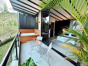 un patio con due sedie e un tavolo su un balcone di Rooca Habitat Guatape a Guatapé