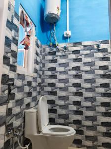 a bathroom with a toilet and a blue wall at Valley View Homestay Sangti in Dirang Dzong +17 photos