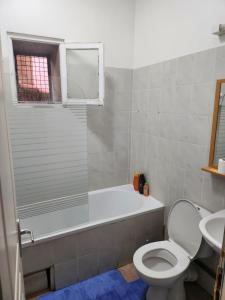 a bathroom with a tub and a toilet and a sink at Pratique in Sète