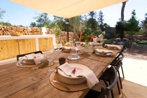 une table en bois avec des assiettes et des serviettes dans l'établissement Spacious & Luxury villa in Ibiza - Santa Gertrudis - Villa Chiquita, à Santa Gertrudis de Fruitera