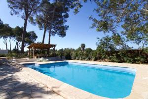 une piscine bleue avec un kiosque et des arbres dans l'établissement Spacious & Luxury villa in Ibiza - Santa Gertrudis - Villa Chiquita, à Santa Gertrudis de Fruitera 35 autres photos