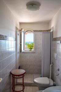 ein Badezimmer mit Toilette und Fenster in der Unterkunft Casa dell'Ospite in Santa Maria di Leuca