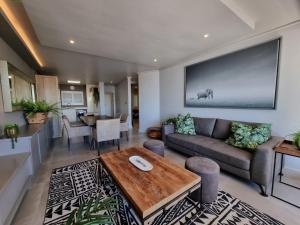 a living room with a couch and a table at Lagoon Shoreline 2 Bedroom Apartment in Cape Town