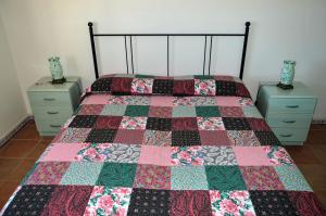 ein Schlafzimmer mit einem Bett, auf dem eine Steppdecke liegt in der Unterkunft Casa dell'Ospite in Santa Maria di Leuca