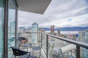 a balcony with two chairs and a view of a city at Executive Unit with Spectacular Views in Vancouver