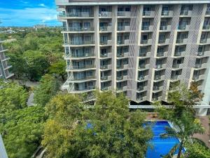 an apartment building with a swimming pool in front of it at Tambuli Blue Premium Seaview in Lapu Lapu City
