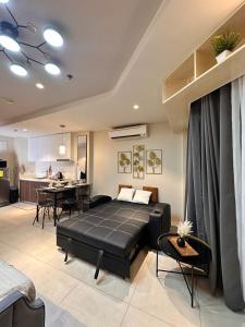 a living room with a black bed and a kitchen at Tambuli Blue Premium Seaview in Lapu Lapu City
