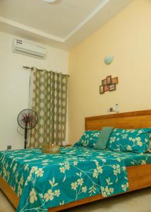 コトヌーにあるDares Salaamの青い掛け布団が敷かれたベッドのある寝室