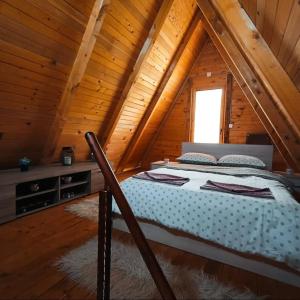 a bedroom with a bed in a wooden cabin at Vikendica Mimiena in Račić +16 photos