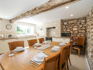 eine Küche und ein Esszimmer mit einem Holztisch und Stühlen in der Unterkunft Pennal Cottage in Oswestry