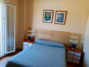 sypialnia z niebieskim łóżkiem i oknem w obiekcie WIFI Los Cisnes 2 dormitorios Primera Linea playa Ayamonte Isla Canela w mieście Isla Canela +32 zdjęcia