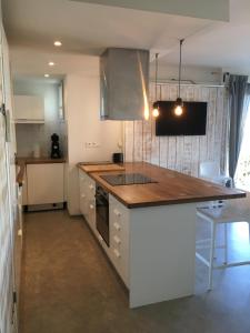 Una cocina con gabinetes blancos y encimera. en Acces Direct Plage, Vue Mer, Climatisation, en La Celle-sous-Gouzon