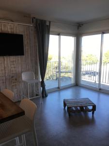 Una sala de estar con una mesa y una gran ventana. en Acces Direct Plage, Vue Mer, Climatisation, en La Celle-sous-Gouzon