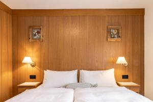 コルヴァーラ・イン・バディーアにあるVilla Resi B&Bの木製の壁のベッドルーム1室、ベッド1台(白い枕付)