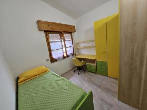 a bedroom with a bed and a desk and a window at Big Apartment in Assemini