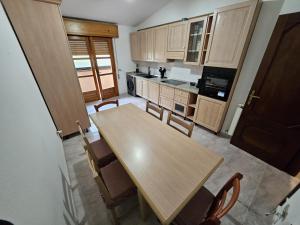 a kitchen with a wooden table and chairs at Big Apartment in Assemini