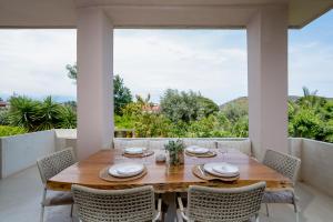 a dining room with a wooden table and chairs at Villa Hyacinth by A&D Properties in Porto Rafti