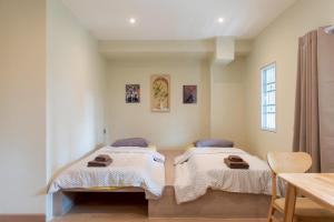 バンコクにあるShizuka House - 500 m walk to BTS Phrom Phongのテーブル付きの部屋にベッドが2つある