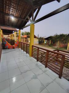 a porch with a wooden fence and a swing at Aconchegante Casa em Gravatá in Gravatá