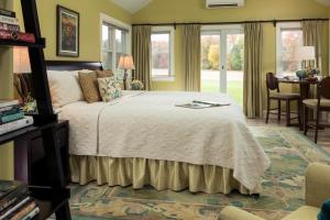 a bedroom with a bed and a table and windows at Inn at Huntingfield Creek in Rock Hall +91 photos