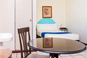 a hotel room with a table and a bed at Capital O Nueva York, Guadalajara centro downtown in Guadalajara