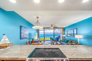 a kitchen with blue walls and a counter top at Kahana Reef 120 by Coldwell Banker Island Vacations in Kahana